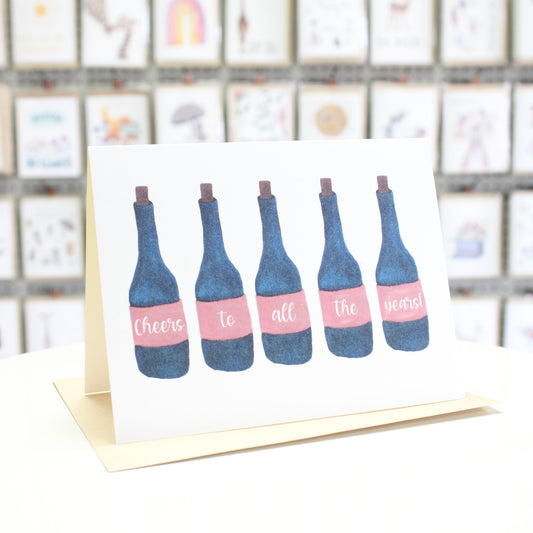 Hand crafted greeting card with watercolor wine bottles reading "cheers to all the years"