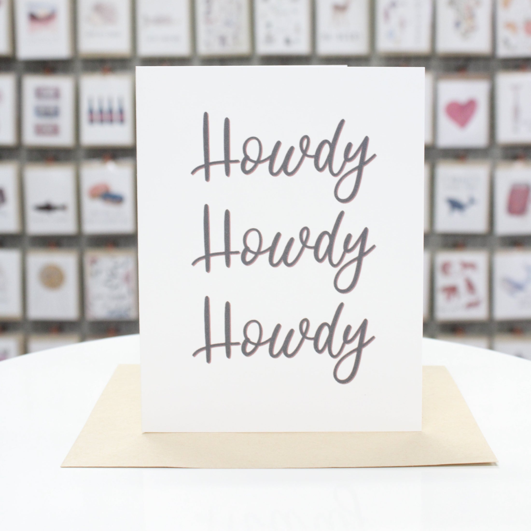 Hand crafted greeting card with printed calligraphy lettering stating, "Howdy Howdy Howdy." 