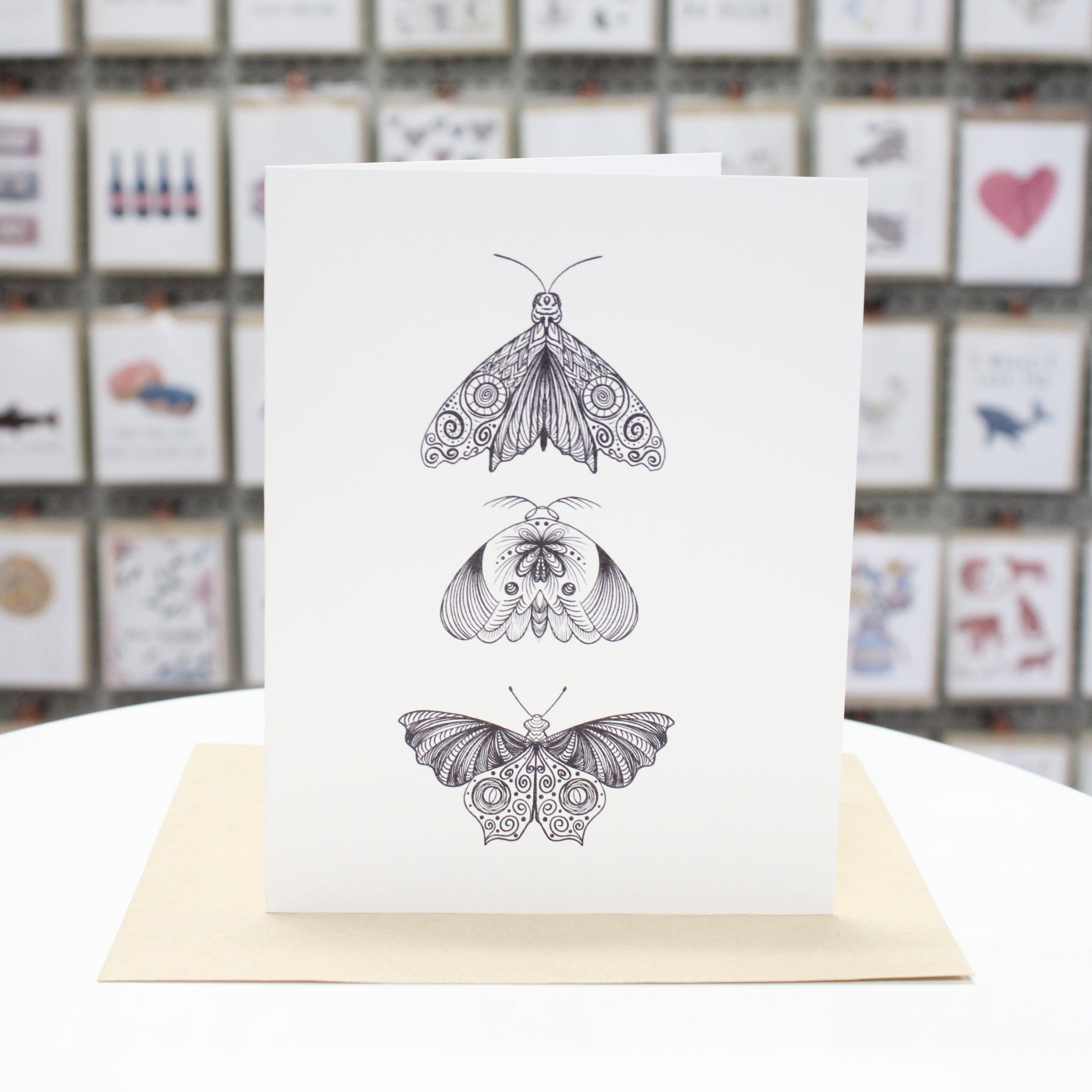 Hand crafted greeting card with three zentangle moths printed in black ink. 