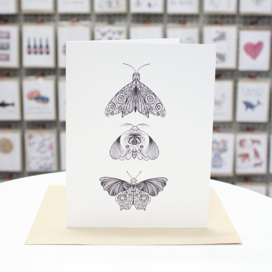 Hand crafted greeting card with three zentangle moths printed in black ink. 