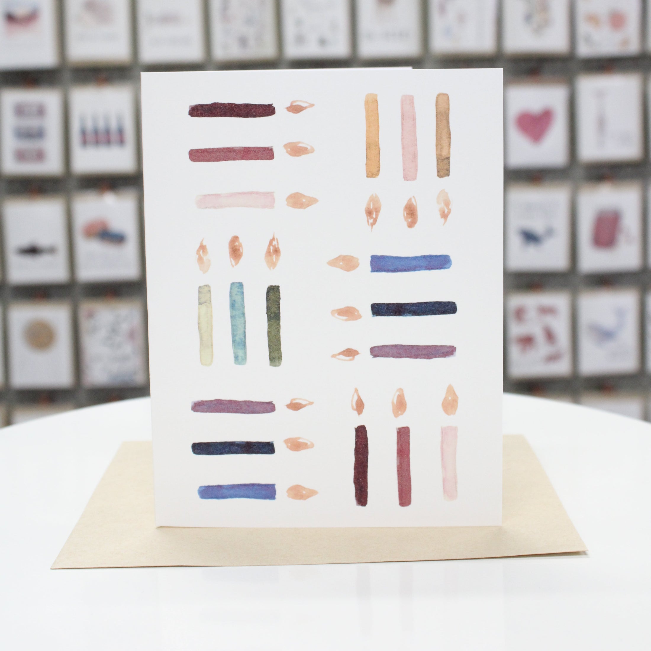 Hand crafted birthday card with watercolor candles grouped in threes going different directions.