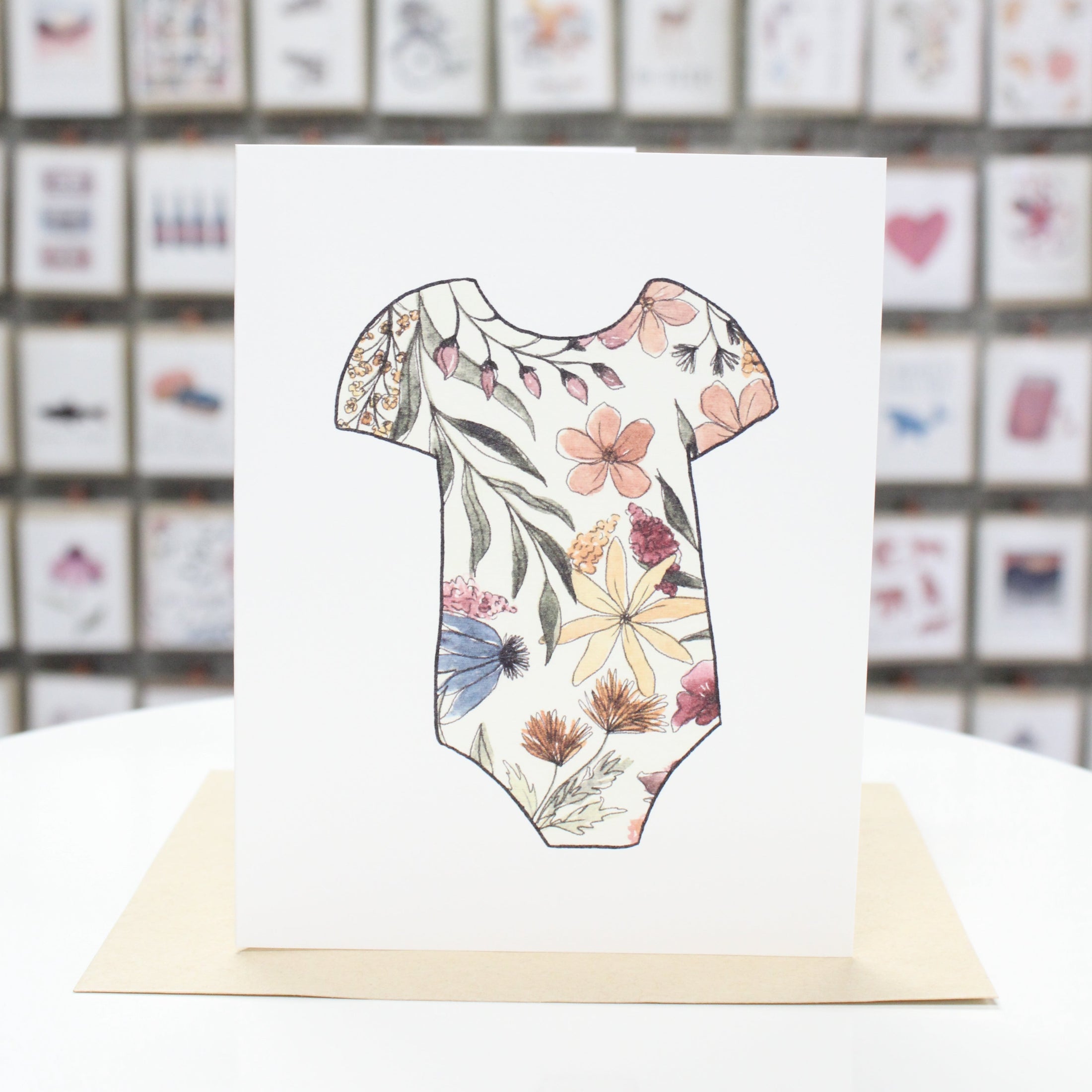Hand crafted greeting card with hand drawn colored flowers printed on a baby onsie.