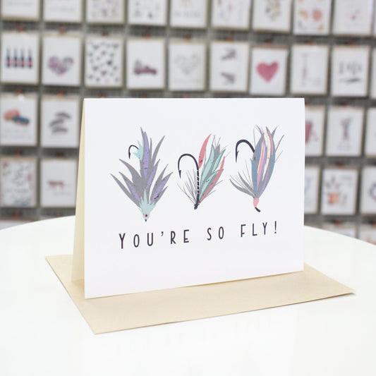 Hand crafted greeting card with printed colored fishing flies. Card stating at the bottom, "You're so fly!"